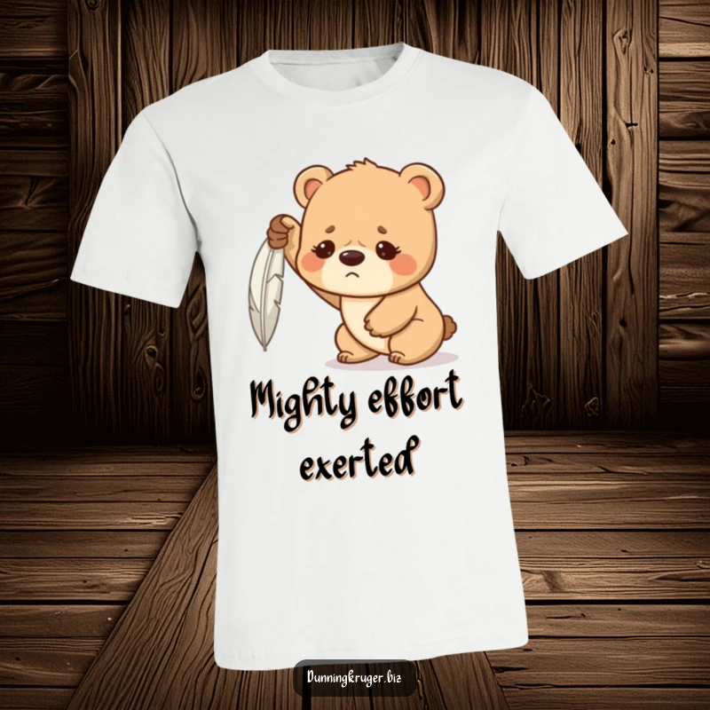 Funny t-shirt displaying a determined bear cub with a furrowed brow, hilariously struggling to lift a feather, a symbol of valiant effort.
